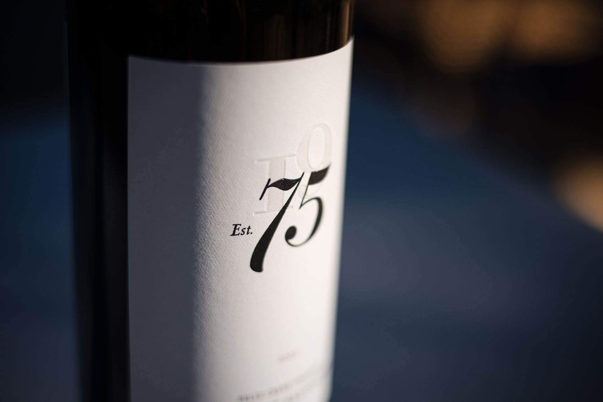 Close-up of the 75 Wine Co label showing the Est. 75 embossed typography